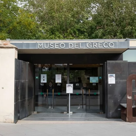 Acceso principal acristalado de museo con rótulo en la parte superior.