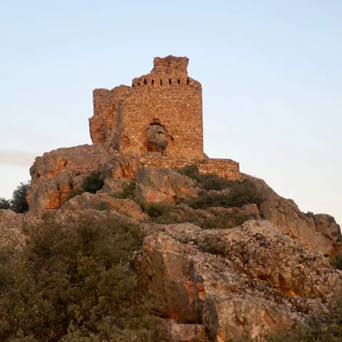 Ruinas de castillo sobre peñas al atardecer
