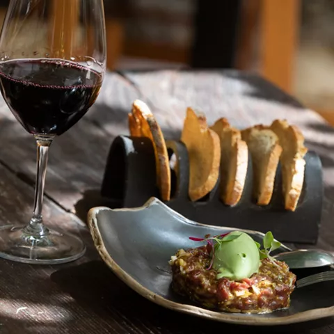 Copa de vino tinto con pan y tartar