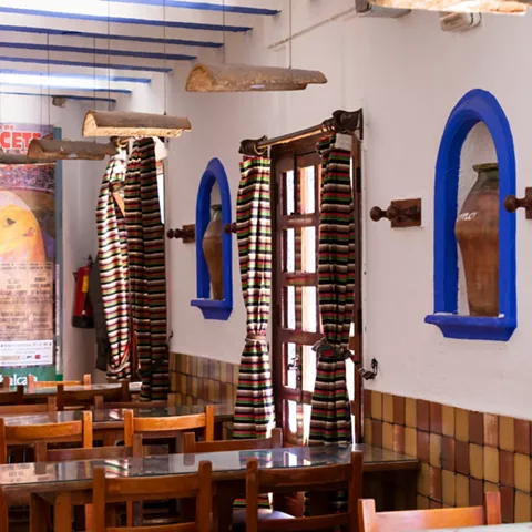 Interior con ventanas arqueadas y cortinas de rayas coloridas