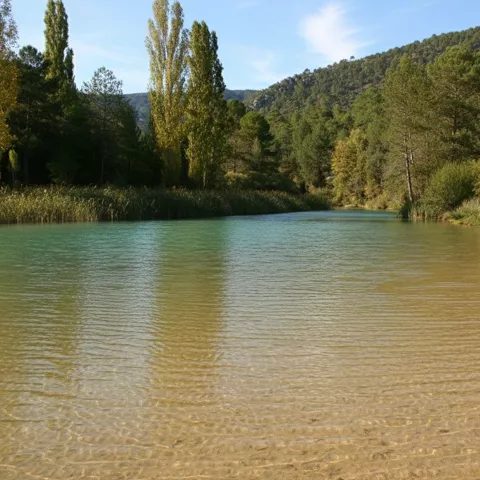 Orilla arenosa de río entre montañas