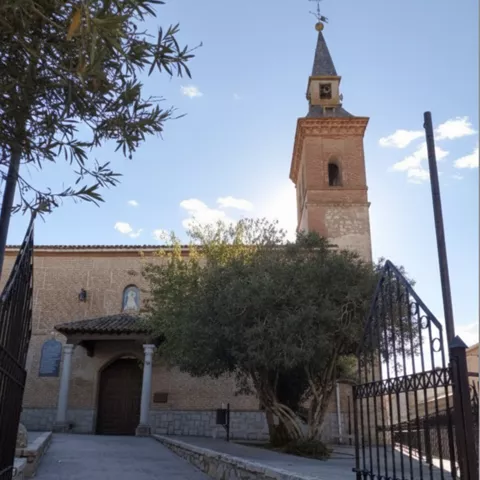 Entrada a iglesia de ladrillo con torre campanario
