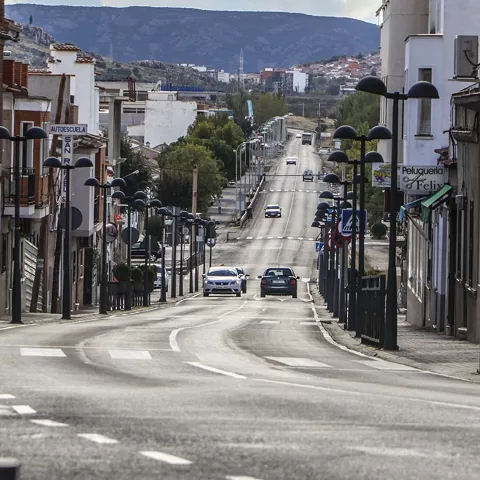Calle principal con edificios residenciales y tráfico urbano