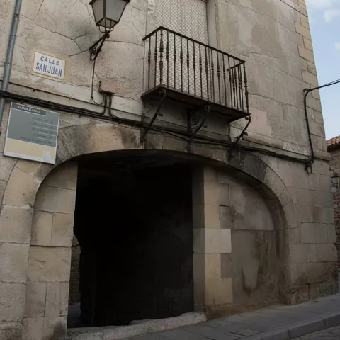 Fachada con balcón y arco en calle antigua