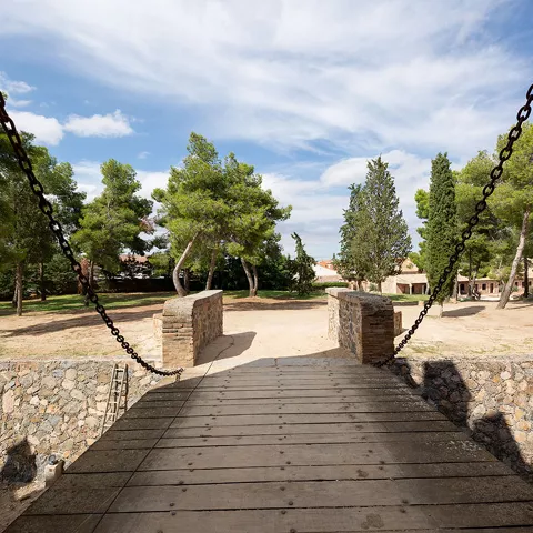 Pasarela de madera con cadenas en la entrada de una fortaleza