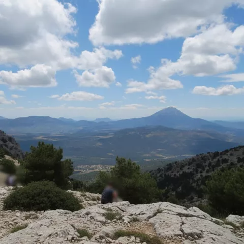 Valle amplio entre montañas bajo cielo con nubes.