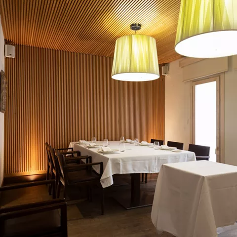 Salón privado con mesa larga y lámparas modernas