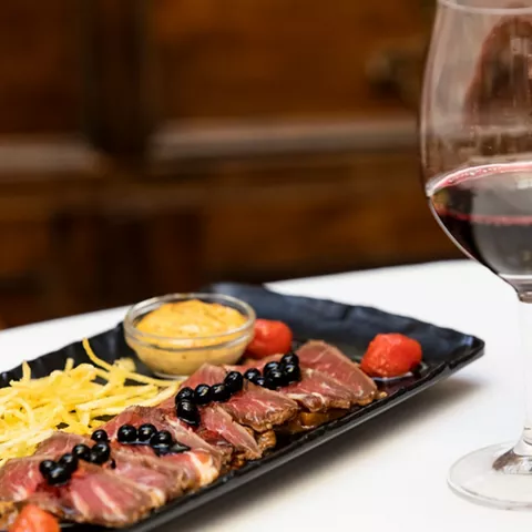 Tartar de carne con frutos rojos y copa de vino