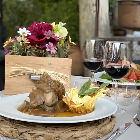 Plato de carne guisada con vino tinto en mesa decorada