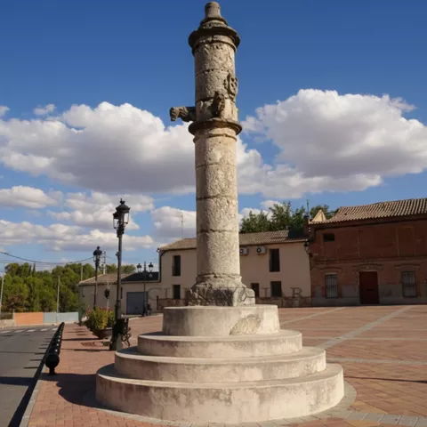 Columna de piedra sobre gradas en una plaza abierta