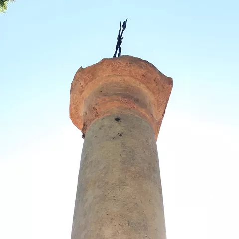 Columna de piedra vista desde abajo contra el cielo.