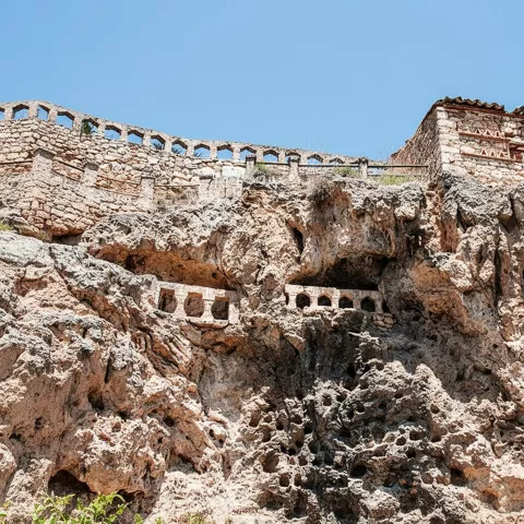 Detalle de roca perforada con balcones de piedra.