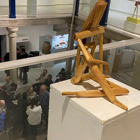 Escultura de madera sobre pedestal en sala