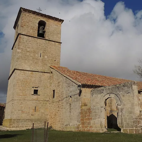 Iglesia rural de piedra bajo cielo nublado.