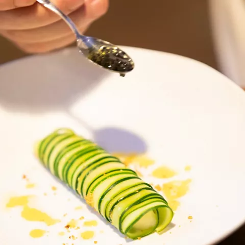 Cucharilla con huevas sobre plato blanco