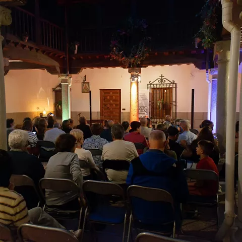 Público sentado en patio interior durante un acto cultural