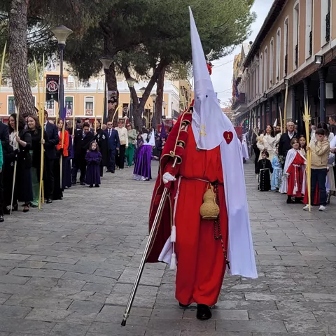 Nazareno con túnica roja caminando en procesión