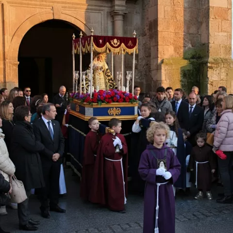 Salida de paso religioso con niños y público frente a la iglesia.