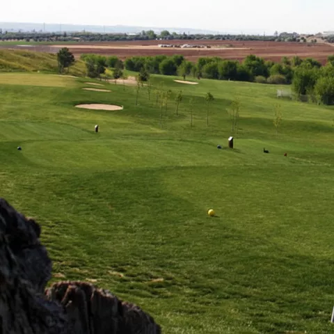 Campo de golf con vistas abiertas y bancos
