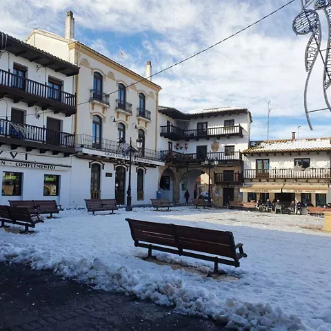 Plaza nevada con bancos y soportales