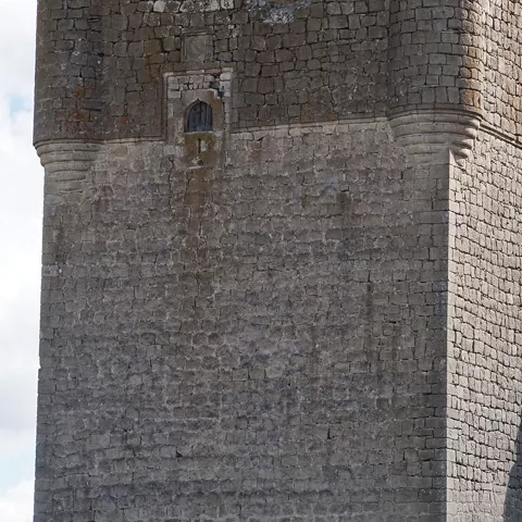 Vista lateral de torre cuadrada con garitones.