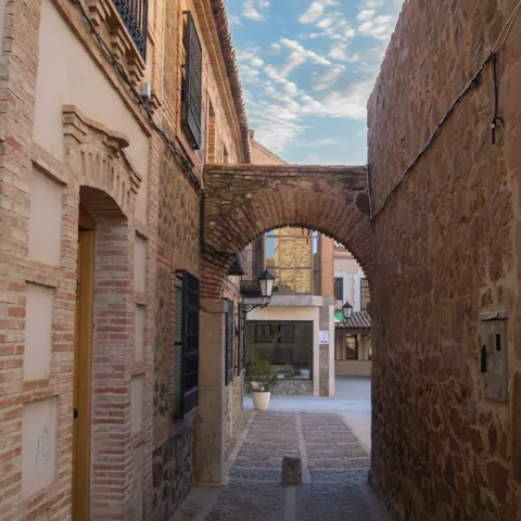 Calle estrecha con arco de piedra y fachadas tradicionales