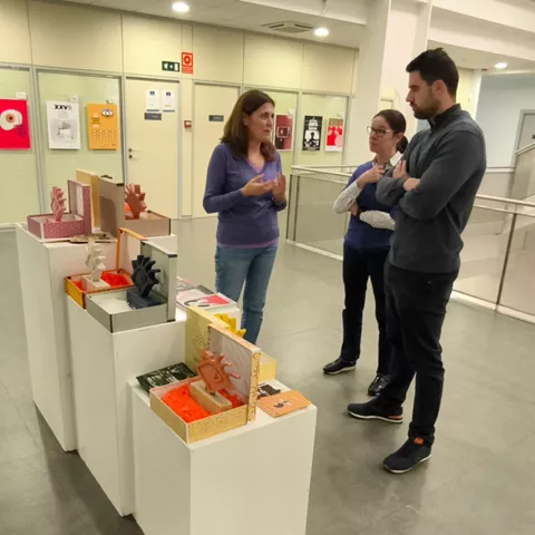 Personas conversando junto a una muestra de trofeos y carteles.