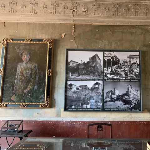 Sala histórica con retratos antiguos y panel informativo enmarcado en la pared.