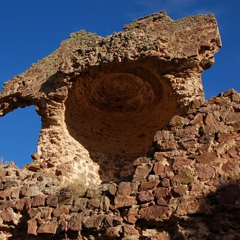 Detalle de arco de piedra derruido en una construcción defensiva antigua.