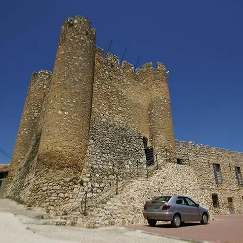 Torre defensiva de piedra rodeada de viviendas.