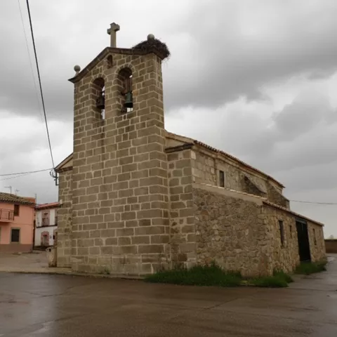 Iglesia de piedra vista en un día nublado desde una calle vacía