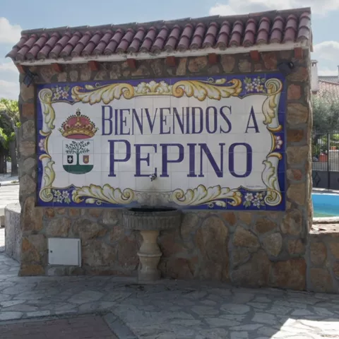 Mural cerámico de bienvenida junto a una fuente