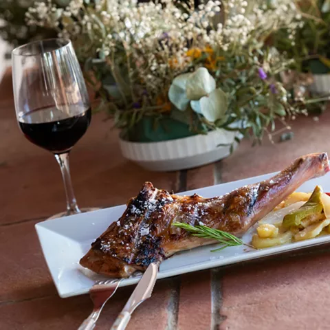 Pierna asada con guarnición y copa de vino