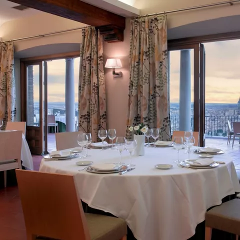 Comedor con mesa redonda junto a ventanales y terraza