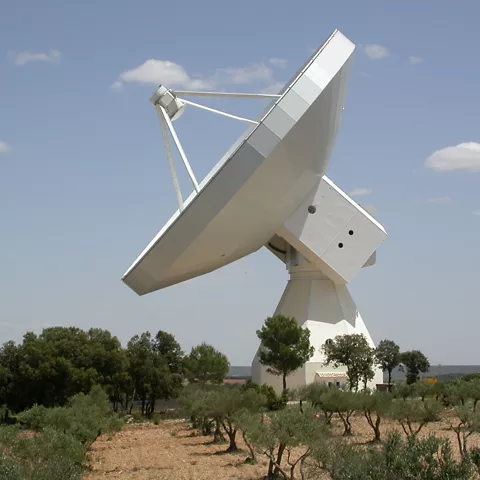 Gran radiotelescopio en paisaje rural.