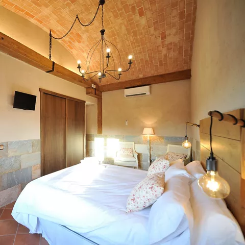 Habitación de matrimonio con baño privado, gran armario empotrado, aire acondicionado y amplios espacios, diseñada para ofrecer una estancia cómoda y funcional en Casa Rural Alma del Tajo.