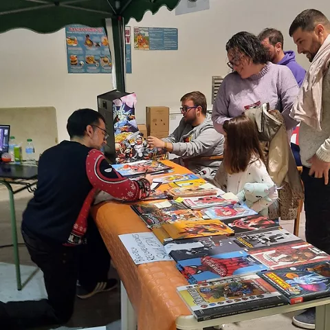 Stand con venta de cómics y asistentes consultando publicaciones.