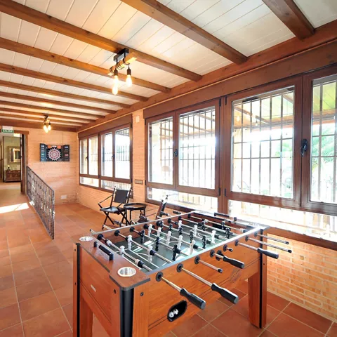 Espacio de ocio cubierto con futbolín profesional y diana electrónica, ideal para disfrutar en familia o con amigos durante la estancia en Casa Rural Alma del Tajo.