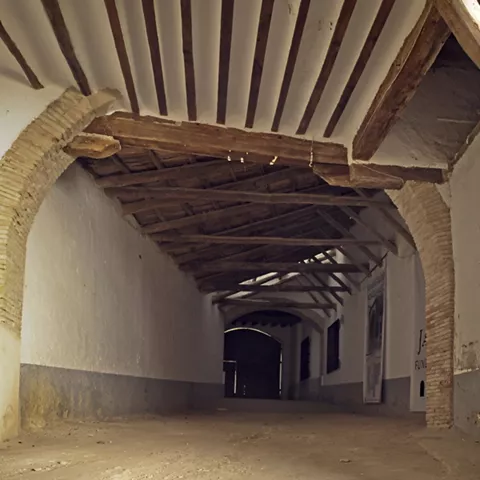 Pasaje cubierto con vigas y arcos de ladrillo