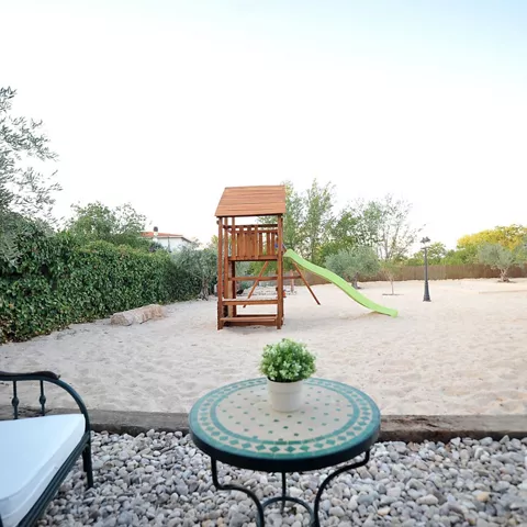 Amplia zona infantil privada con parque de juegos y arenero, diseñada para que los más pequeños disfruten con total tranquilidad mientras los adultos aprovechan el resto de las instalaciones de Casa Rural Alma del Tajo.