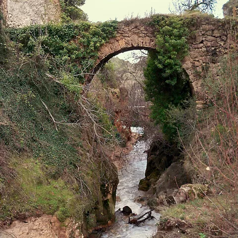 Acueducto de piedra con río