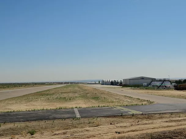 Vista lateral de pista y edificios técnicos en un aeródromo.