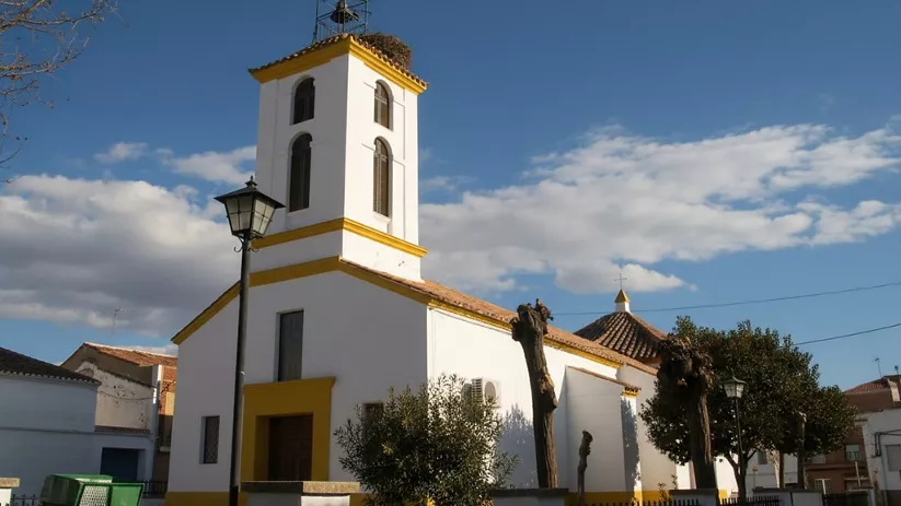 Iglesia parroquial de fachada blanca con detalles amarillos
