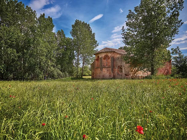 Pequeña iglesia románica entre prados.
