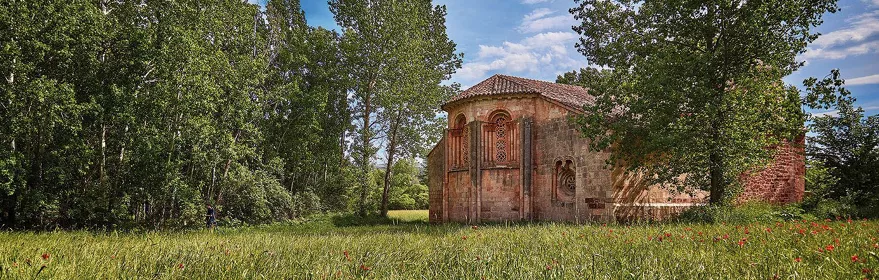 Pequeña iglesia románica entre prados.