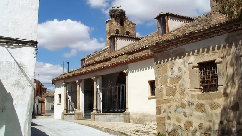 Iglesia tradicional con espadaña y nido de cigüeñas
