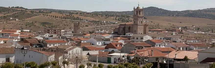 Vista general del casco urbano con tejados rojizos y paisaje de colinas.