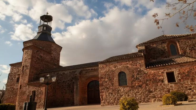Iglesia parroquial de piedra con torre y entrada principal
