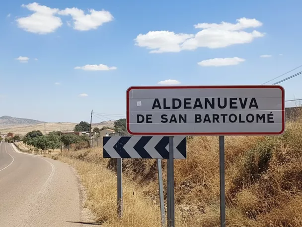 Señal de carretera junto a vía rural con paisaje abierto
