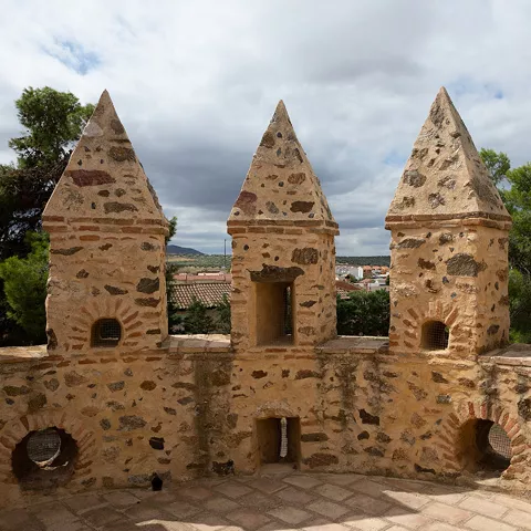Detalle de almenas de piedra con pequeñas aberturas defensivas